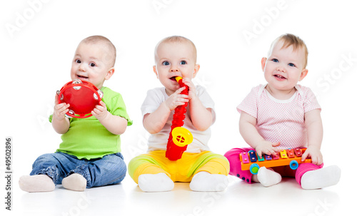 Photo: Children playing with musical toys. Isolated on white background Children playing with musical toys. Isolated on white background