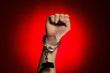 fist and handcuffs opened over red background