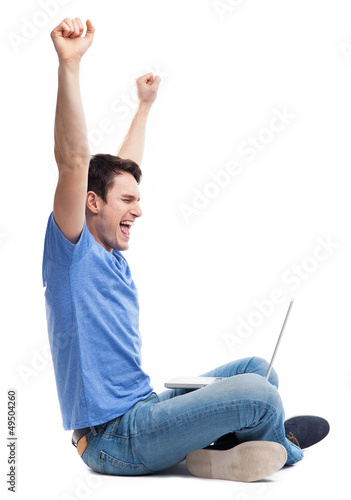 Photo: Excited young man using laptop Excited young man using laptop