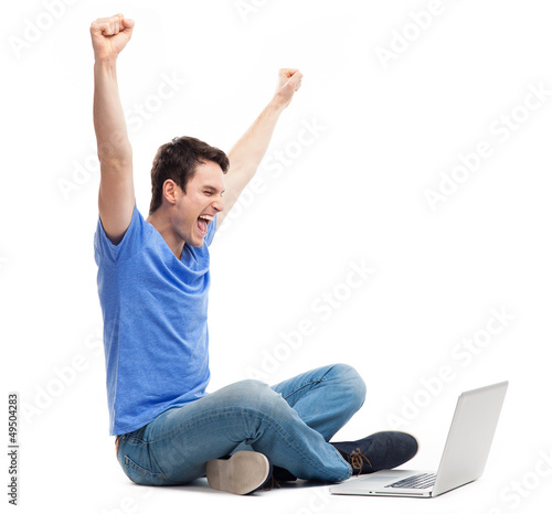 Photo: Excited young man using laptop Excited young man using laptop