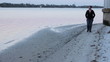Depressed woman walking along the shore