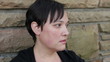 Sad woman sitting against a wall close up 2