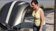 Woman with car trouble opens her hood