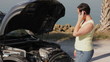 A woman having car trouble talking on her cellphone