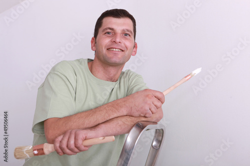 Photo: Cheerful painter on a ladder Cheerful painter on a ladder