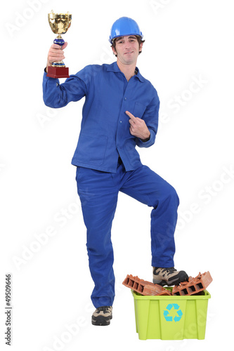 Photo: Worker holding gold cup Worker holding gold cup