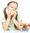 Little girl choosing between apples and sweets