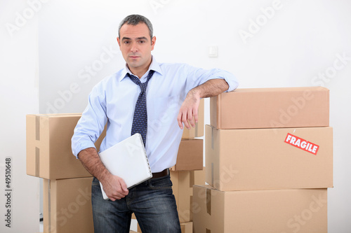 Photo: Man stood by stacked boxes Man stood by stacked boxes