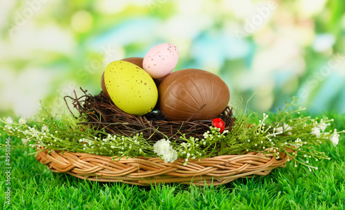 Photo: Composition of Easter and chocolate eggs in nest Composition of Easter and chocolate eggs in nest