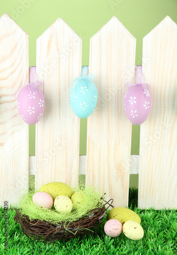 Photo: Art Easter background with eggs hanging on fence Art Easter background with eggs hanging on fence