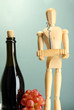 Mannequin with corkscrew and wine bottle, on grey background