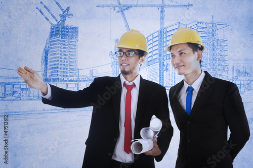 Photo: Architect explains blueprint plan Architect explains blueprint plan