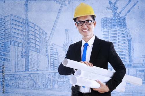 Photo: Architect holds blueprint plans Architect holds blueprint plans
