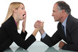 Woman arm wrestling with her boss