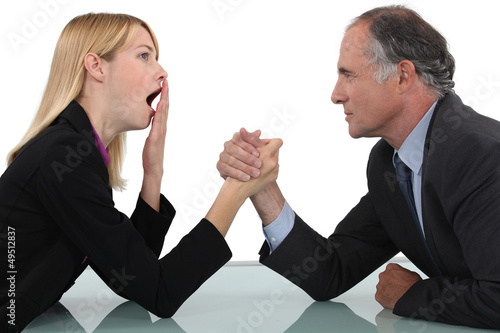 Photo: Woman arm wrestling with her boss Woman arm wrestling with her boss