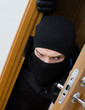 Photo: Male burglar in mask breaking into the house Male burglar in mask breaking into the house