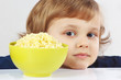 Beautiful blonde child with a bowl of millet porridge