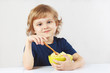 Little blonde boy breakfast a millet cereal