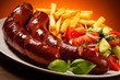 Grilled sausages, French fries and vegetables