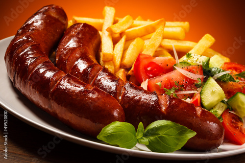 Photo: Grilled sausages, French fries and vegetables Grilled sausages, French fries and vegetables