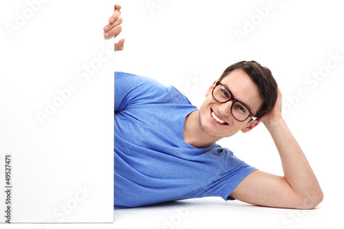 Photo: Man lying down with blank poster Man lying down with blank poster