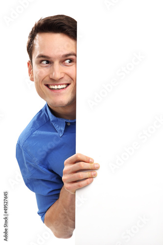 Photo: Man peeping over blank poster Man peeping over blank poster
