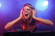 Excited DJ girl on decks on the party