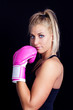 beautiful, fit woman wearing hot pink boxing gloves