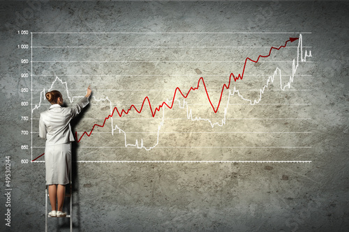 Photo: businesswoman drawing diagrams on wall businesswoman drawing diagrams on wall