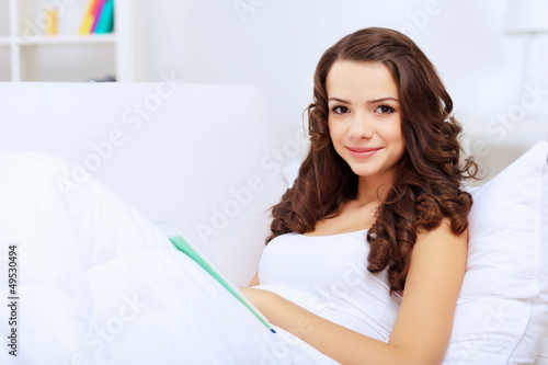 Photo: Young woman at home with a book Young woman at home with a book