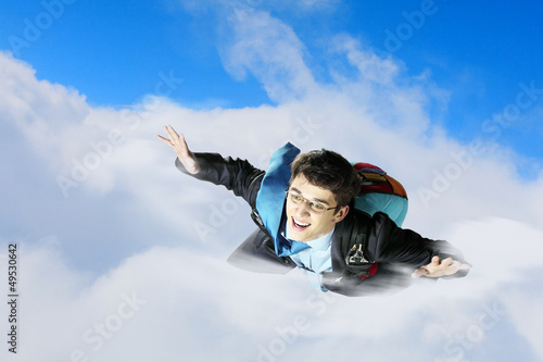 Photo: Young businessman flying with parachute on back Young businessman flying with parachute on back