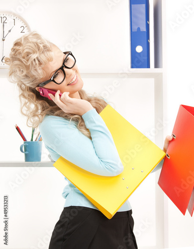 Photo: woman with folders and cell phone woman with folders and cell phone