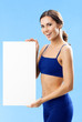 Woman in fitnesswear showing signboard, over blue