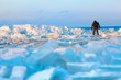 Man walking on icy beach along the Baltic sea