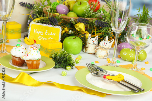 Photo: Serving Easter table on room background Serving Easter table on room background