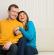 Photo: Happy couple sitting on sofa Happy couple sitting on sofa