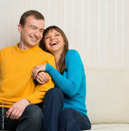 Photo: Happy couple sitting on sofa Happy couple sitting on sofa