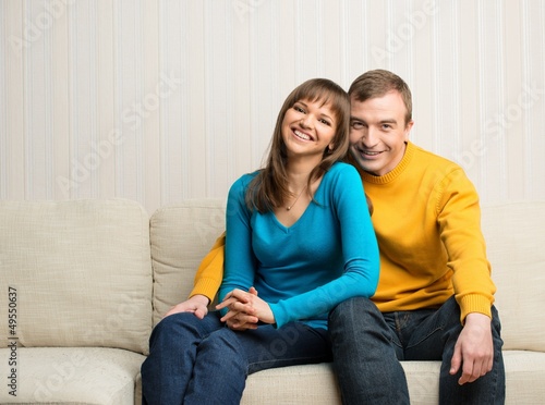 Photo: Happy couple sitting on sofa Happy couple sitting on sofa