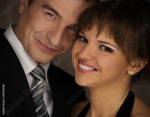 Photo: Happy elegant couple in classic dress Happy elegant couple in classic dress