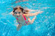 Underwater child in swimming pool, girl swims and having fun