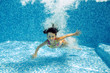 Underwater child in swimming pool, girl swims and having fun
