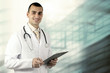 Smiling medical doctor with stethoscope on the hospitals backgro