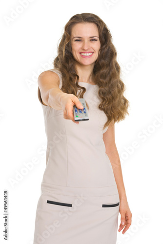 Photo: Happy young woman switching channels with tv remote control Happy young woman switching channels with tv remote control