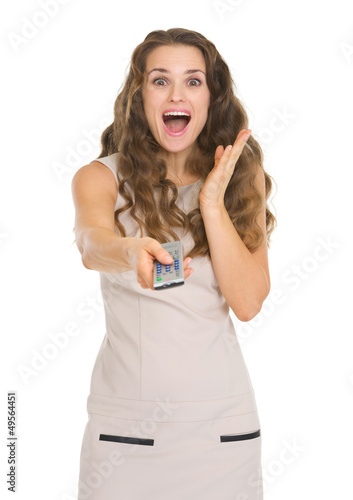 Photo: Surprised young woman with tv remote control Surprised young woman with tv remote control