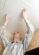 Man glues ceiling tile
