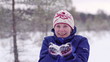 Woman blows snowflakes from her  hands