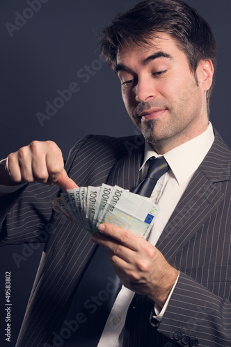 Photo: Geschäftsmann beim Geld scheffeln Geschäftsmann beim Geld scheffeln