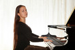 A girl with her hair playing the piano