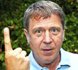man in garden raises his finger to warn