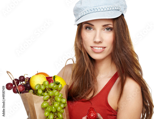 Photo: Portrait of happy young woman holding a shopping bag full of gro Portrait of happy young woman holding a shopping bag full of gro